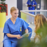 Female nurse talking to a patient in the waiting area